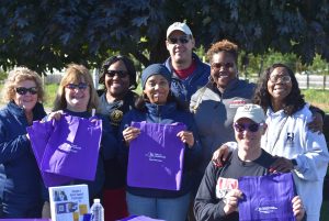 PEF leaders displaying purple drawstring bags that were given out to attendees.